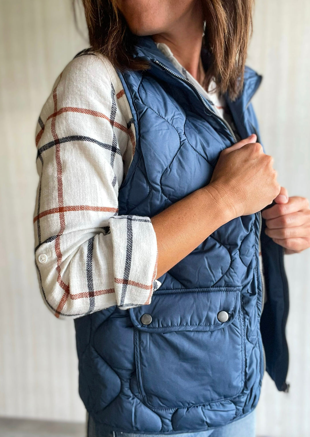 Thread & Supply Blue Vest paired with white, orange, and blue flannel and jeans. Central Illinoi Women's Clothing Boutique.