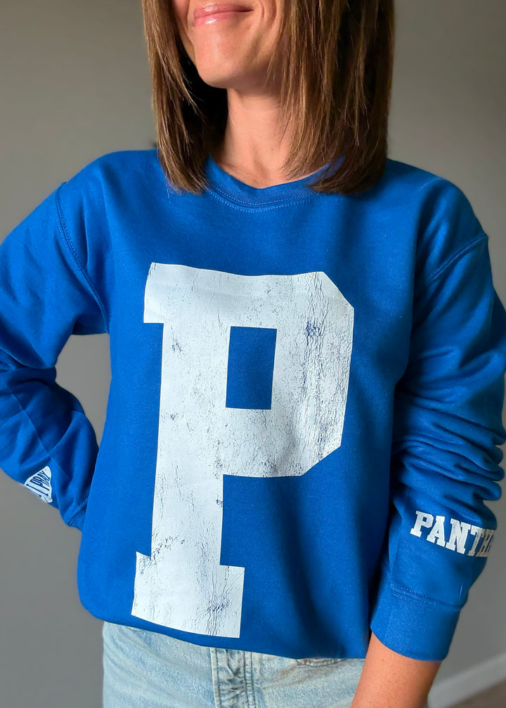 Woman wearing a blue sweatshirt with a large white 'P' on a plain background. St. Joseph Panther's Sweatshirt Fan Gear.