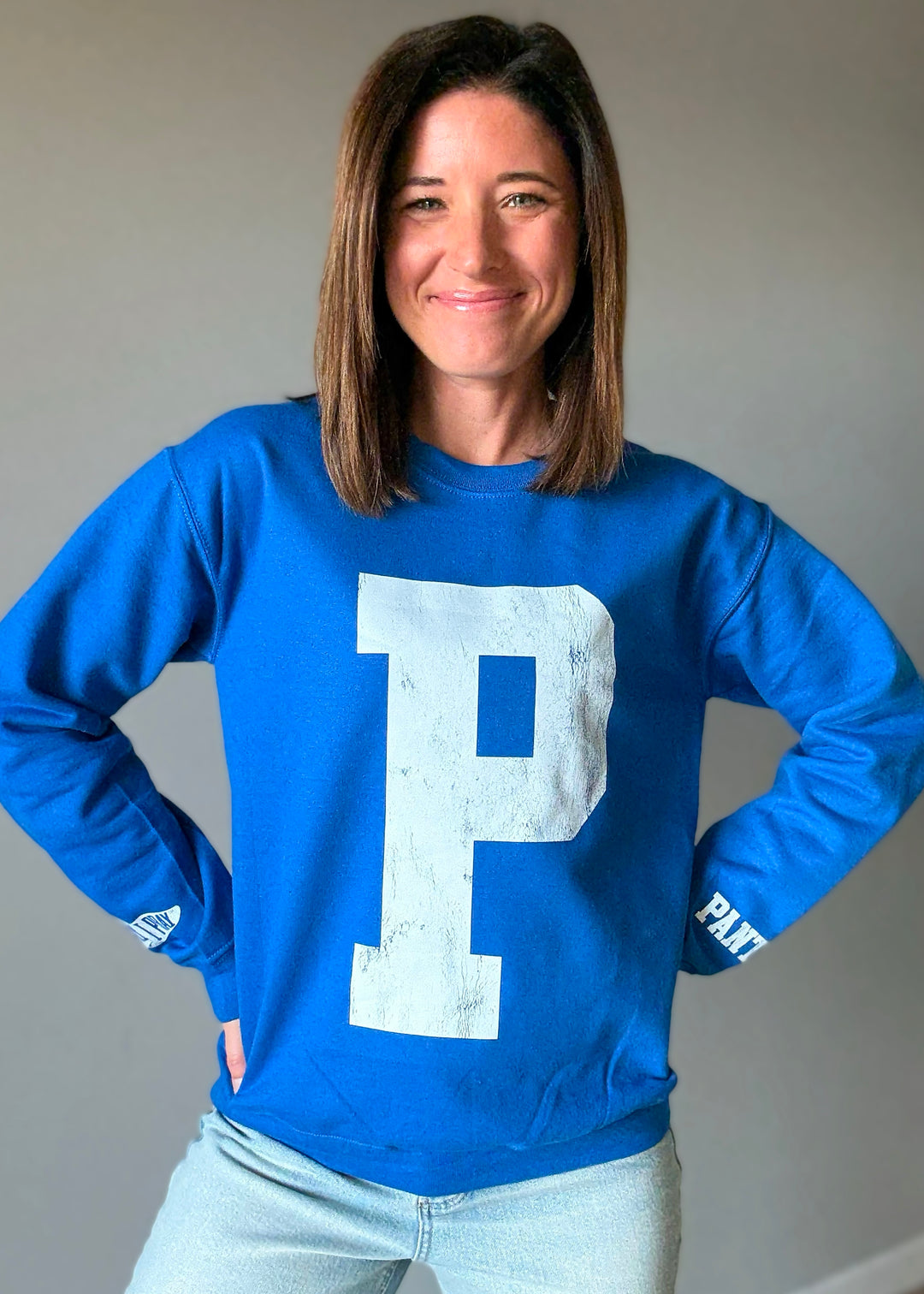 Woman wearing a blue sweatshirt with a large white 'P' on a plain background. St. Joseph Panther's Sweatshirt Fan Gear.