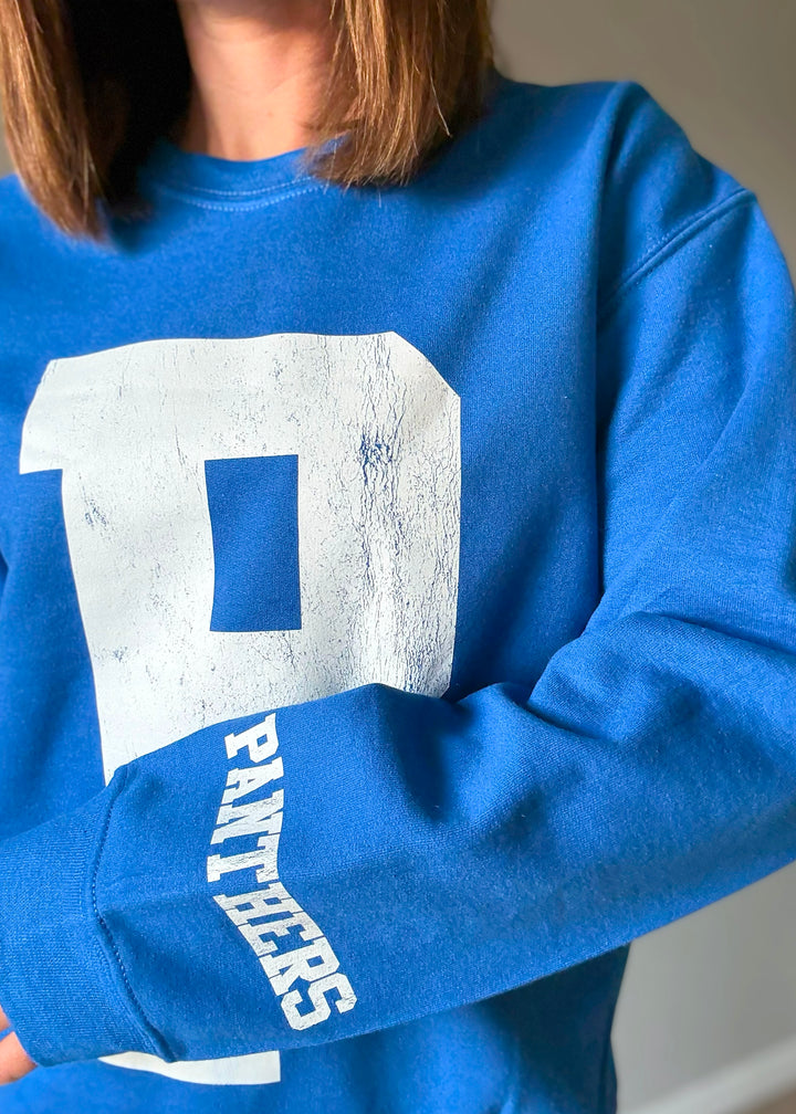 Woman wearing a blue sweatshirt with a large white 'P' on a plain background. St. Joseph Panther's Sweatshirt Fan Gear.