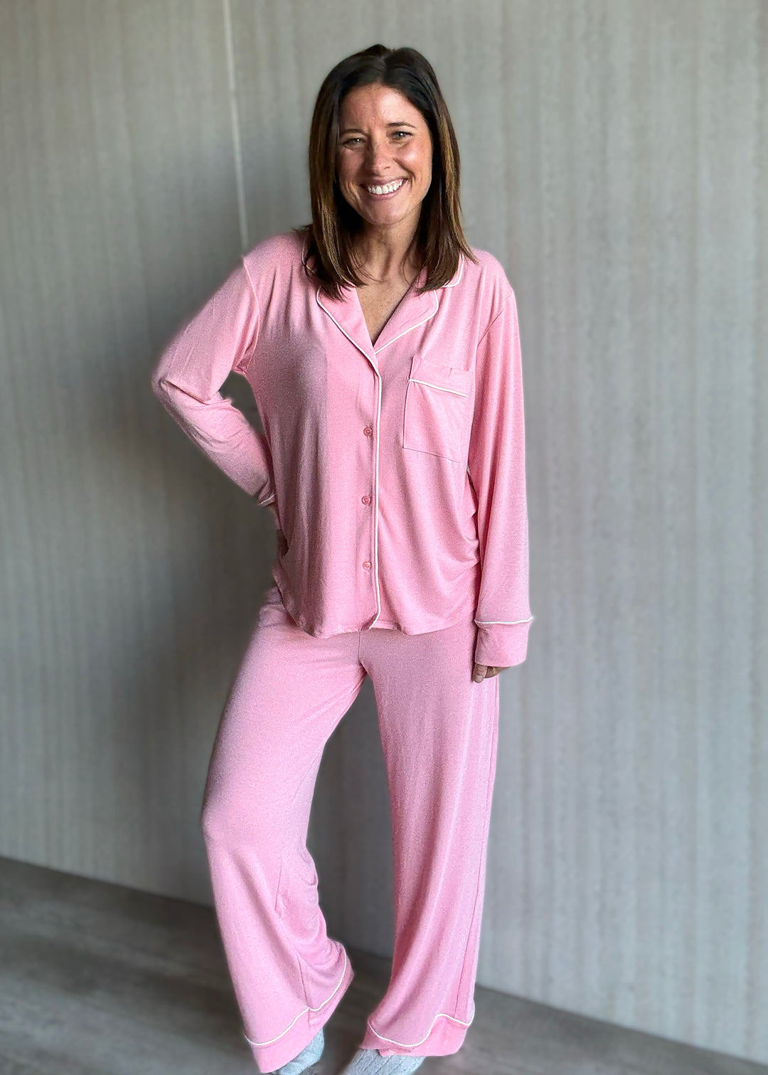 Woman wearing a pink pajama set against a neutral background