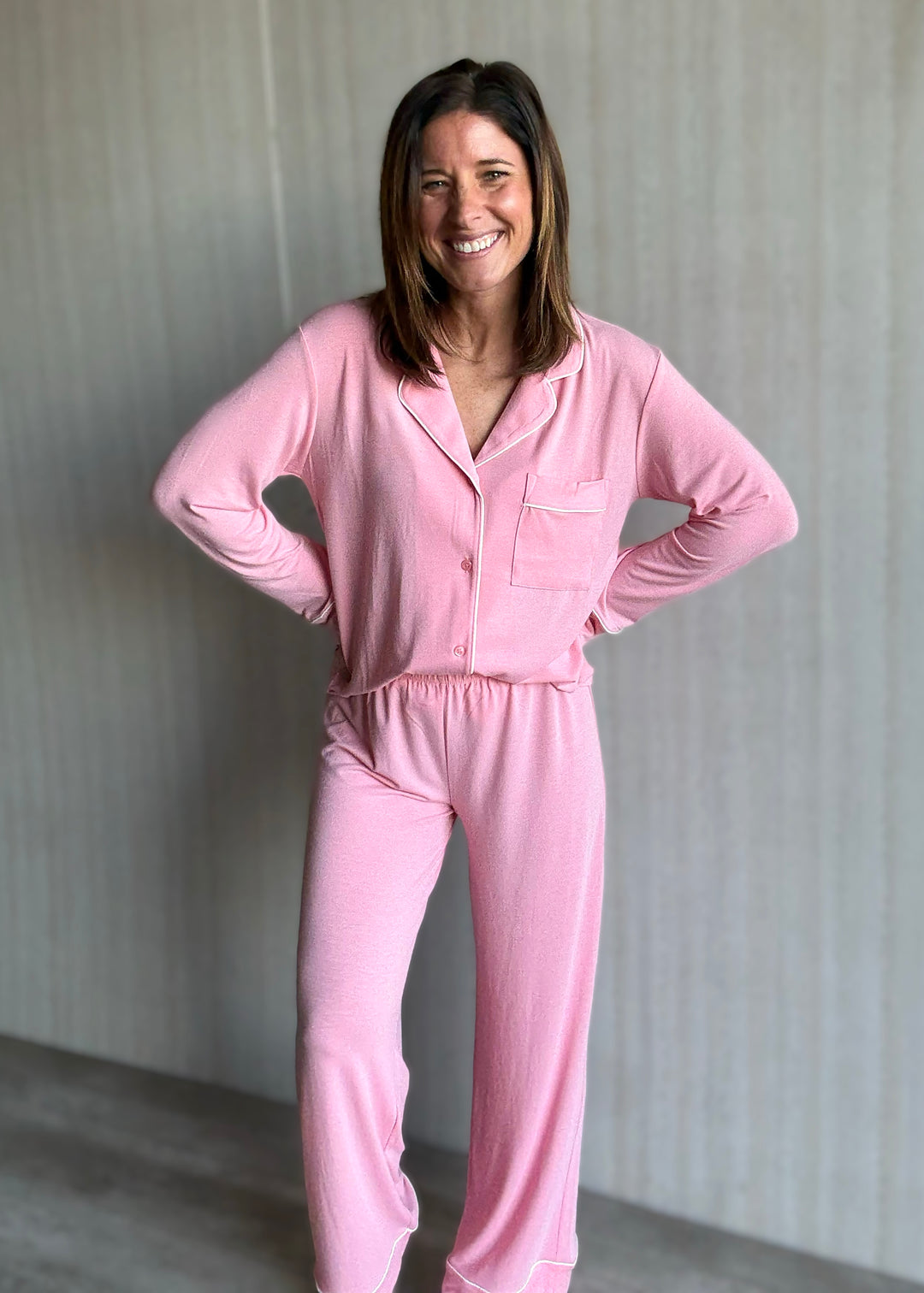 Woman wearing a pink pajama set against a neutral background