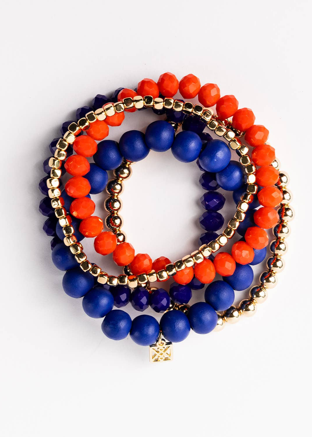 Stack of blue and orange beaded bracelets on a white background