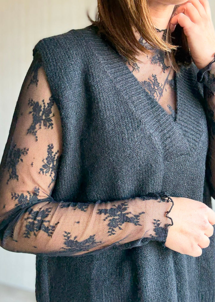 Women's Oversized Black Sweater Vest w/V-neck line paired over a sheer black lace long sleeve top.
