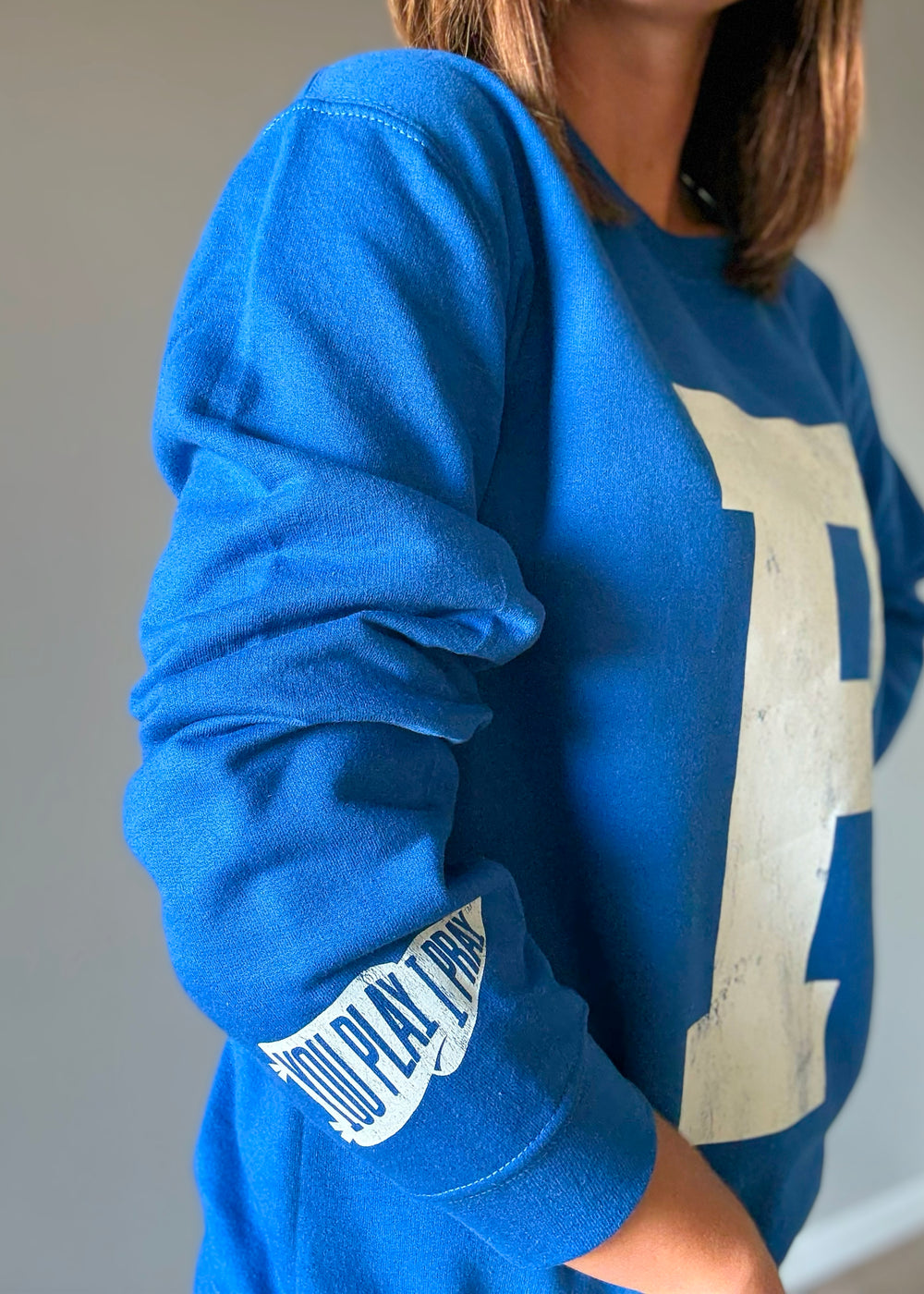 Woman wearing a blue sweatshirt with a large white 'P' on a plain background. St. Joseph Panther's Sweatshirt Fan Gear.