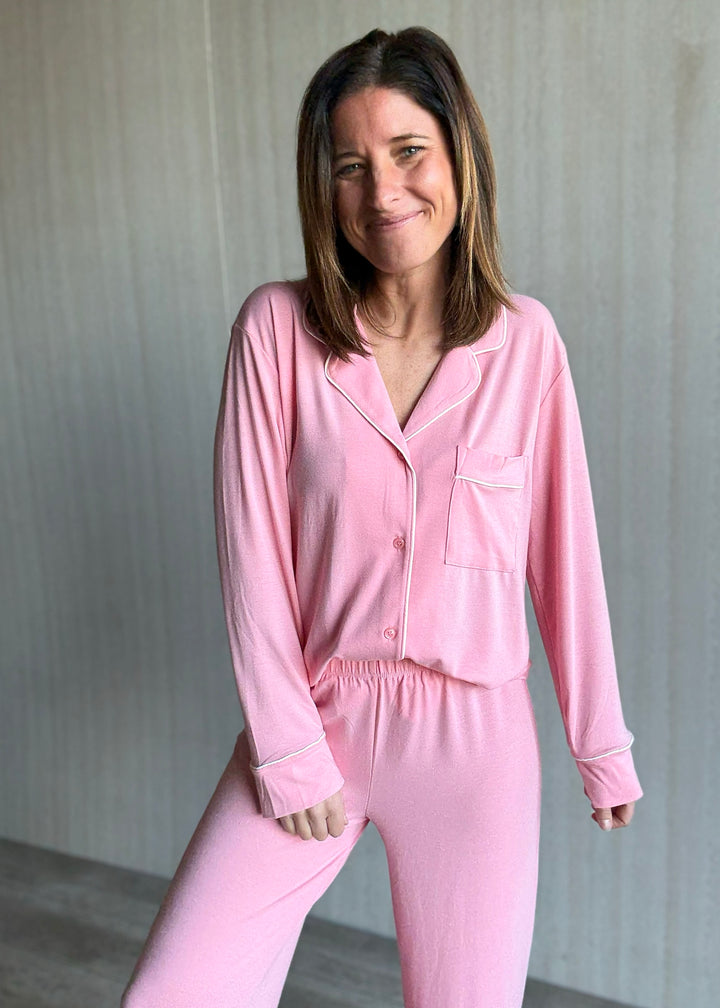 Woman wearing a pink pajama set against a neutral background