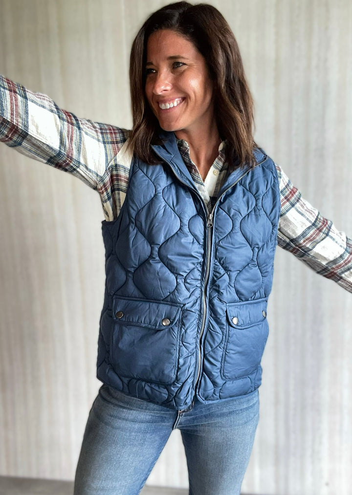 Thread & Supply Blue Vest paired with white, maroon, and blue flannel and jeans. Central Illinoi Women's Clothing Boutique.