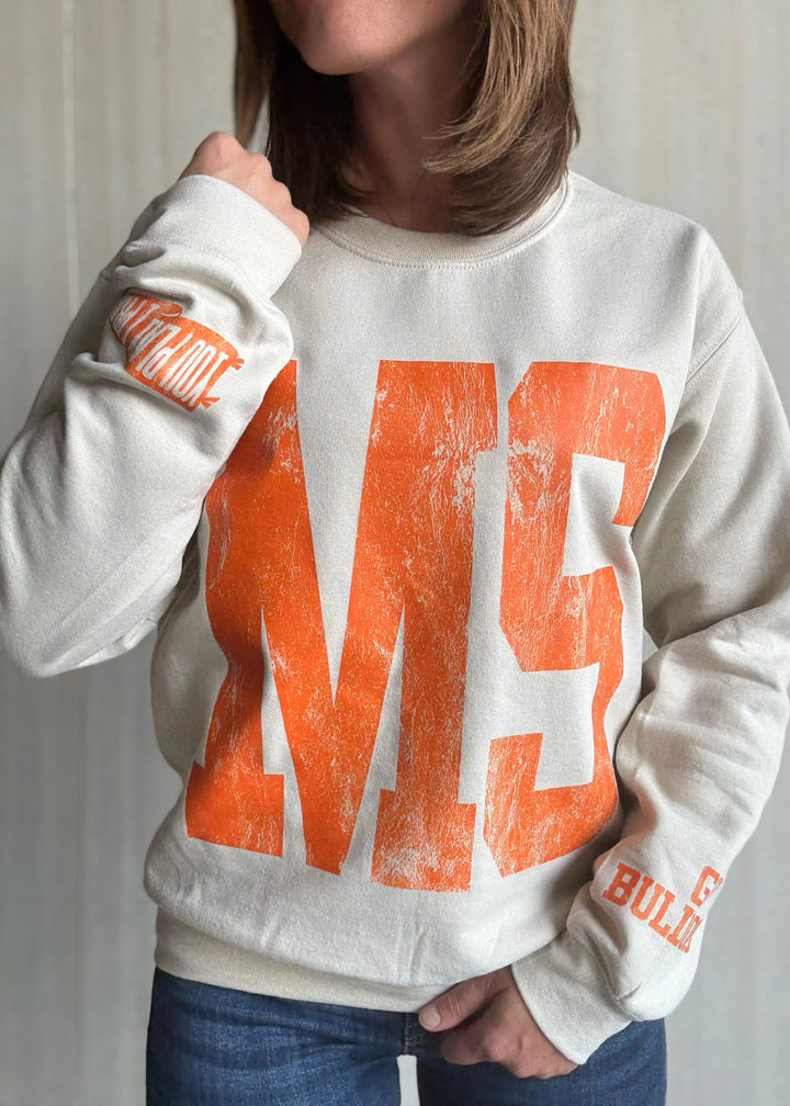 Person wearing a white sweatshirt with orange text and graphics | Women's Mahomet Seymour Cream and Orange Sweatshirt Fanwear