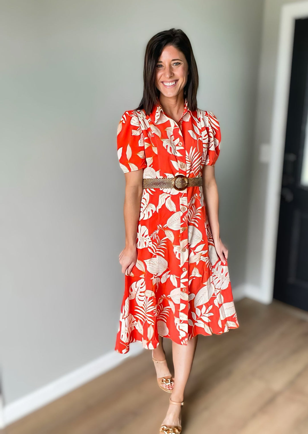 Orange dress with white palm print. Midi shirt dress with buttons all the way down and a collar at the top. Comes with a belt.