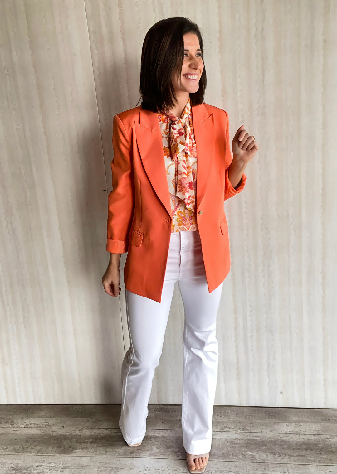Women's Light Orange Blazer with dress blouse and white flare pants.