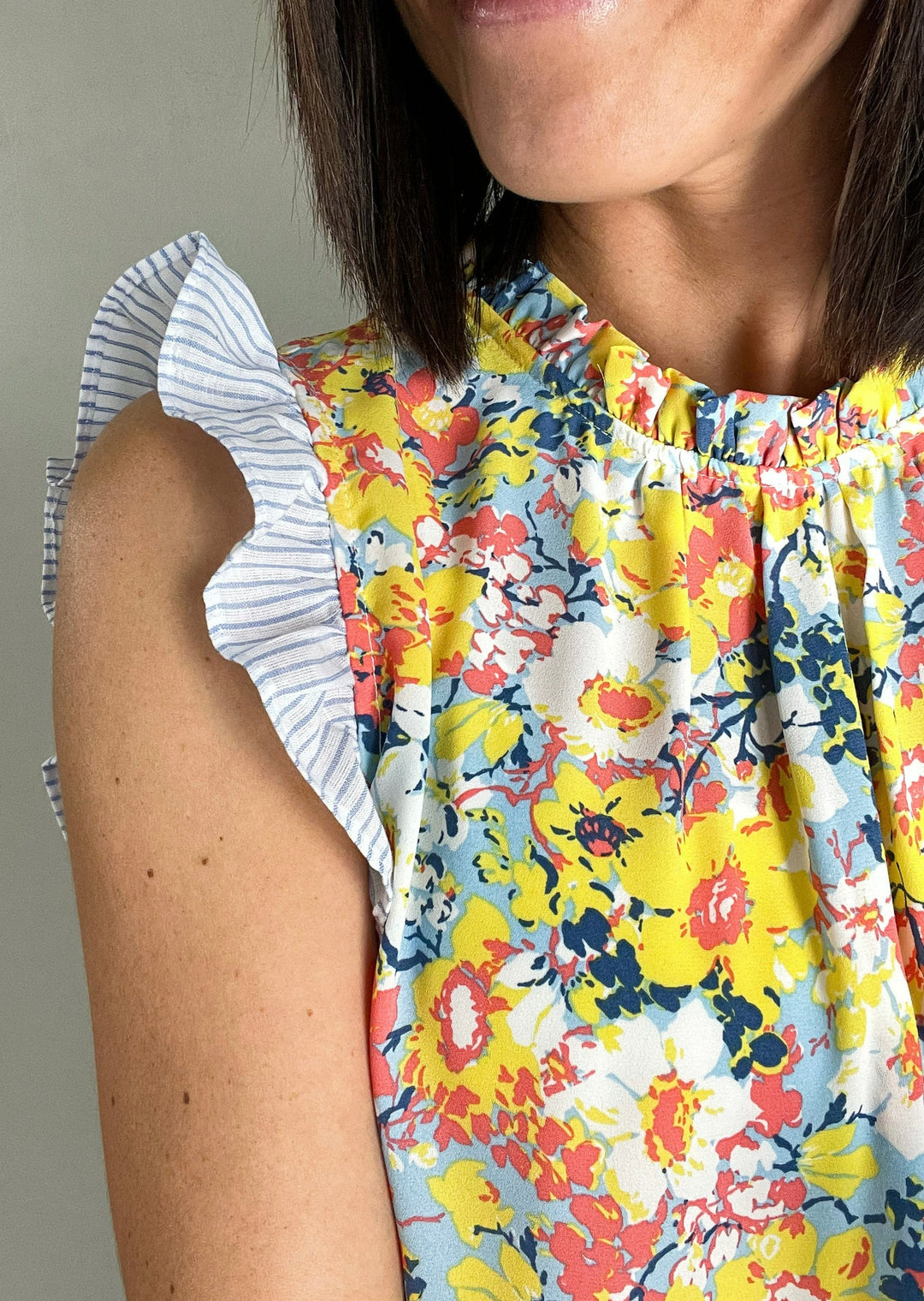 Orange and Yellow Floral Sleeveless Blouse with blue and white striped flutter sleeves.