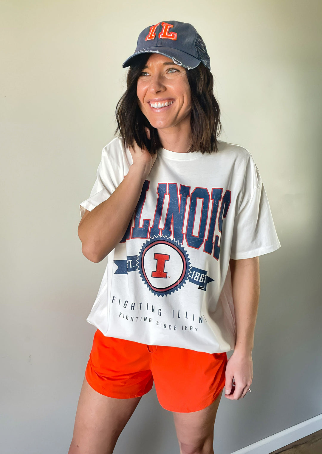 This Illinois Ivory Oversized Tee features an oversized fit just as the title says. Text graphics state "ILLINOIS" across the top chest in a light blue distressed lettering with an orange outline followed by an Illinois emblem with "Est. 1867". "FIGHTING ILLINI | FIGHTING SINCE 1867" stated across the bottom of the shirt and light blue. The short sleeves and crew neck add a classic touch, making it easy to wear with a variety of outfits.
